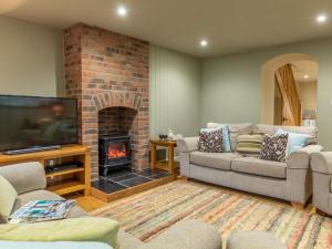 a living room with a couch and a fireplace at 3 Bed in Axminster oc-bloco in Axminster