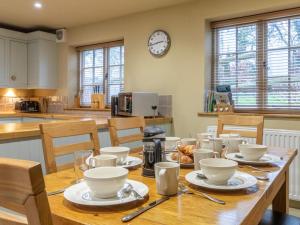 a kitchen with a wooden table with dishes on it at 3 Bed in Axminster oc-bloco in Axminster