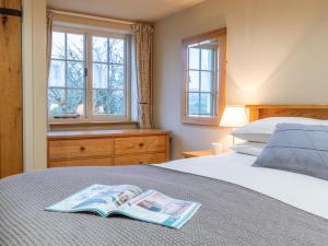 a bedroom with a bed with a book on it at 3 Bed in Axminster oc-bloco in Axminster