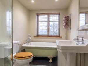 a bathroom with a tub and a toilet and a sink at 3 Bed in Axminster oc-bloco in Axminster +12 photos