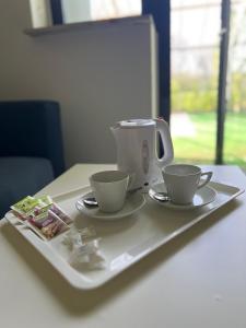 a tray with two cups and a tea kettle on it at Hotel Margrethe in Gadbjerg