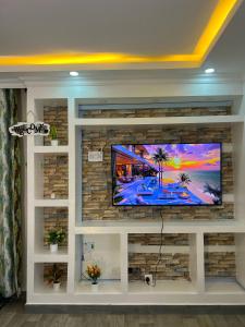 a living room with a flat screen tv on a stone wall at Kwetuhaven in Kiambu