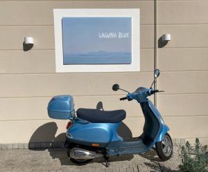 a blue scooter parked in front of a building at Seeblick VILLA LAGUNA BLUE - Private Spa - Whirlpool & Sauna in Gardone Riviera