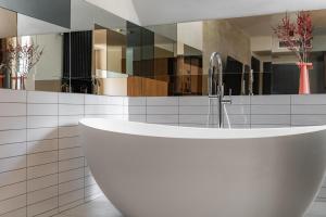 ein Badezimmer mit einer weißen Badewanne und einem Waschbecken in der Unterkunft Forest Hotel in Krakau