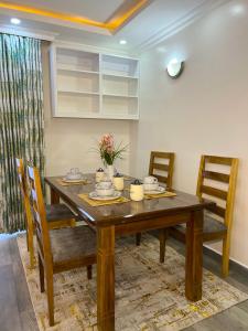 a dining room with a wooden table and chairs at Kwetuhaven in Kiambu +11 photos