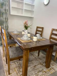 a wooden dining room table with chairs and flowers on it at Kwetuhaven in Kiambu