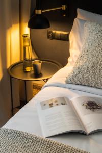 ein offenes Buch auf einem Bett mit einem Tisch in der Unterkunft Forest Hotel in Krakau