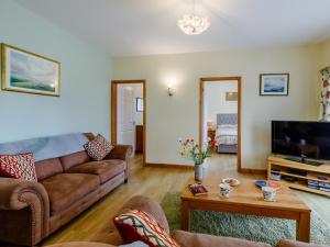 a living room with a couch and a tv at 2 Bed in Ottery St Mary oc-lambs in Ottery Saint Mary