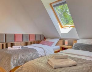 a attic room with three beds and a window at Ulinia Zacisze Dom Comfort 70m2 in Ulinia +78 photos