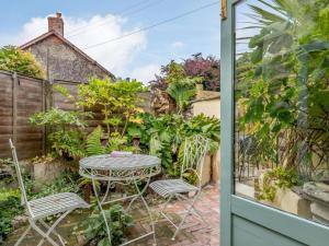 a patio with a table and chairs in a garden at 1 Bed in Chulmleigh oc-82389 in Chulmleigh