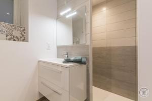 a white bathroom with a sink and a mirror at Gîte G1304 in Sottevast +12 photos