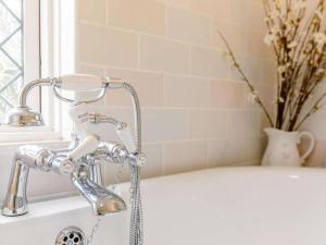 a bathroom with a bath tub with a faucet at 1 Bed in Chulmleigh oc-82389 in Chulmleigh