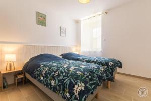 a bedroom with a bed with a blue comforter at Gîte G1304 in Sottevast