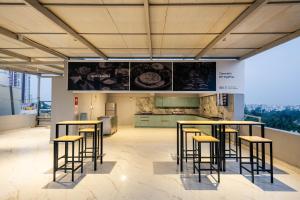 a group of stools in a room with a kitchen at C Suites Gilbert in Bangalore