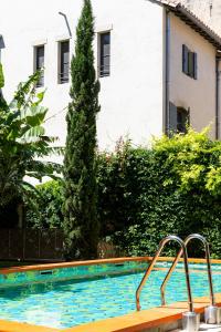 a swimming pool with a tree in the background at L'Arlatan in Arles
