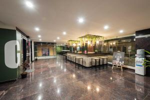 a lobby with a restaurant with tables and chairs at C Suites Gilbert in Bangalore