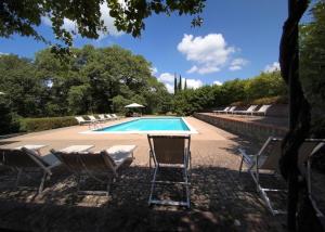 a swimming pool with chairs and a table next to at Castello di Montalto in Castelnuovo Berardenga +30 photos