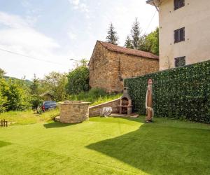 a backyard with a lawn with a grill and a building at Perbone 1573 - Premium Restored Villa in Toano