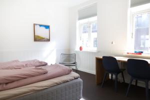a bedroom with a bed and a desk and chairs at Gertruds Petit Hotel in Odense