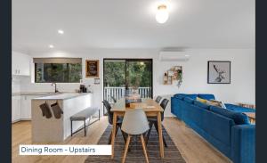 a living room with a blue couch and a table at Maleny Lakeside Retreat l 5BDRM l Firepit l Pets Ok in Maleny