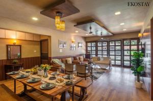 a living room with a table and a couch at EKOSTAY Gold - Amara Villa in Alibaug +26 photos
