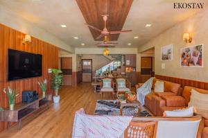 a living room with a couch and a ceiling fan at EKOSTAY Gold - Amara Villa in Alibaug