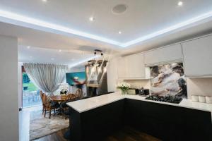 a kitchen with white cabinets and a dining room at Arnie in Longley