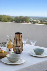 a table with plates and glasses and a bottle of wine at La Pau Apartament in Mollerussa