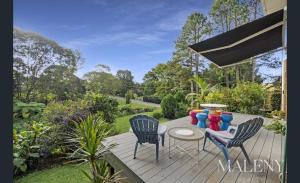 a wooden deck with two chairs and a table at Maleny Lakeside Retreat l 5BDRM l Firepit l Pets Ok in Maleny