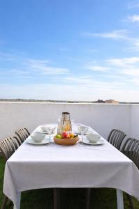 a white table with a bowl of fruit on it at La Pau Apartament in Mollerussa