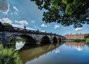 a bridge over a river with people on it at Habberley Hall Flat in Shrewsbury