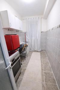 a kitchen with white walls and a red appliance at Ploiești Centru in Ploieşti
