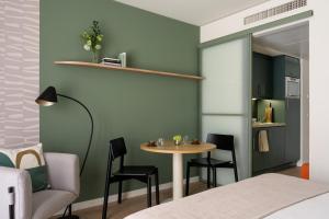 a room with a table and chairs and a kitchen at Bob W Munich City Centre in Munich