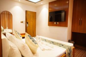 a hotel room with a bed and a tv at Fiona Luxury Resort in Gazipur +3 photos