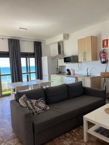 a living room with a couch and a kitchen at A la Orilla del Mar in Matalascañas