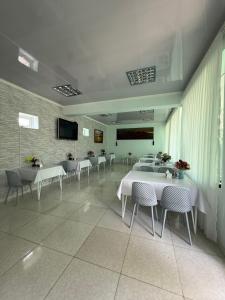 a large room with tables and chairs and a television at Гостевой дом Асель in Cholpon-Ata