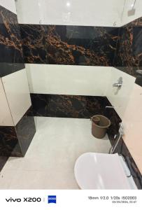 a bathroom with a toilet and a sink at Dev Hotel & Restaurant in Vrindāvan