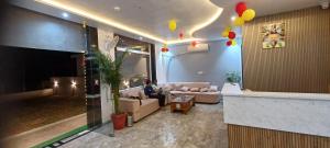 a person sitting on a couch in a living room at Dev Hotel & Restaurant in Vrindāvan