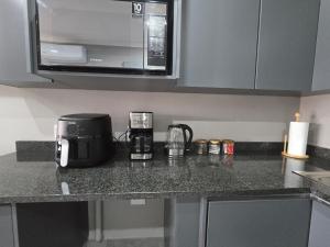 a kitchen counter with a coffee maker and a microwave at The Oak GuestUnit in Kathu +3 photos
