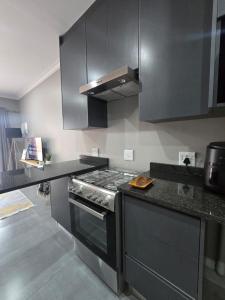 a kitchen with a stove and a counter top at The Oak GuestUnit in Kathu