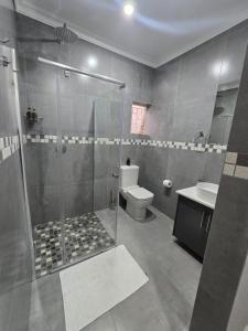 a bathroom with a shower and a toilet at The Oak GuestUnit in Kathu