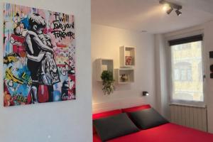 a bedroom with a red bed and a painting on the wall at Suite Casina al Lago in Lavena Ponte Tresa
