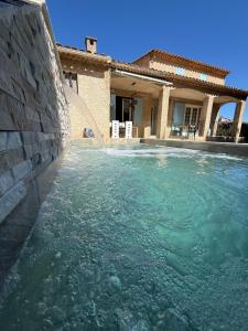 a pool of water in front of a house at La Laurisienne in Lauris