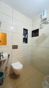 a bathroom with a toilet and a sink at TJ VISTA LIVING in Cochin +23 photos