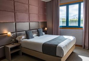 a bedroom with a large bed with a large window at Alda Carballo in Carballo +93 photos