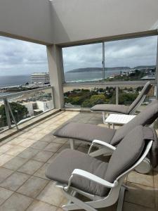 a balcony with chairs and a view of the ocean at Nice Sea View in Plettenberg Bay