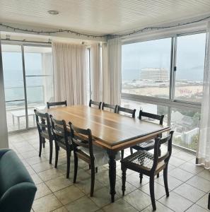 a dining room with a table and chairs and a large window at Nice Sea View in Plettenberg Bay