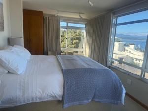 a bedroom with a bed and a large window at Nice Sea View in Plettenberg Bay
