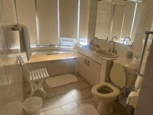 a bathroom with a toilet and a tub and a sink at Nice Sea View in Plettenberg Bay +8 photos