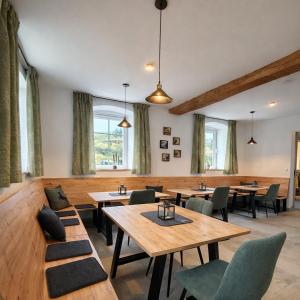 a restaurant with wooden tables and chairs and windows at Bio Hof Bichler in Mariazell +15 photos